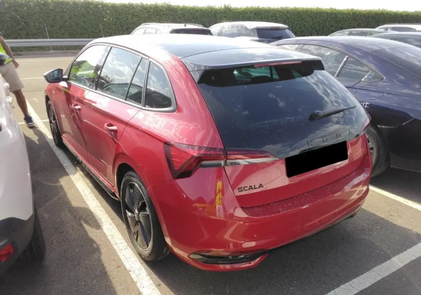 Vue 3/4 arrière droite d'une Skoda Scala TSI 116 DSG7 Monte-Carlo Rouge Velvet avec toit panoramique et hayon électrique.