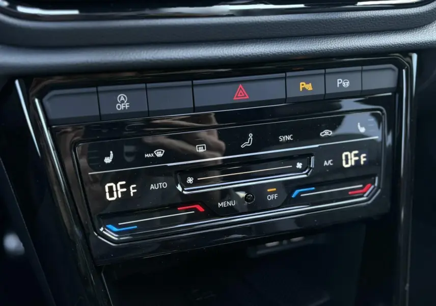 Gros plan sur la commande de climatisation automatique du Volkswagen T-Roc 2025 avec affichage digital et boutons tactiles noirs.