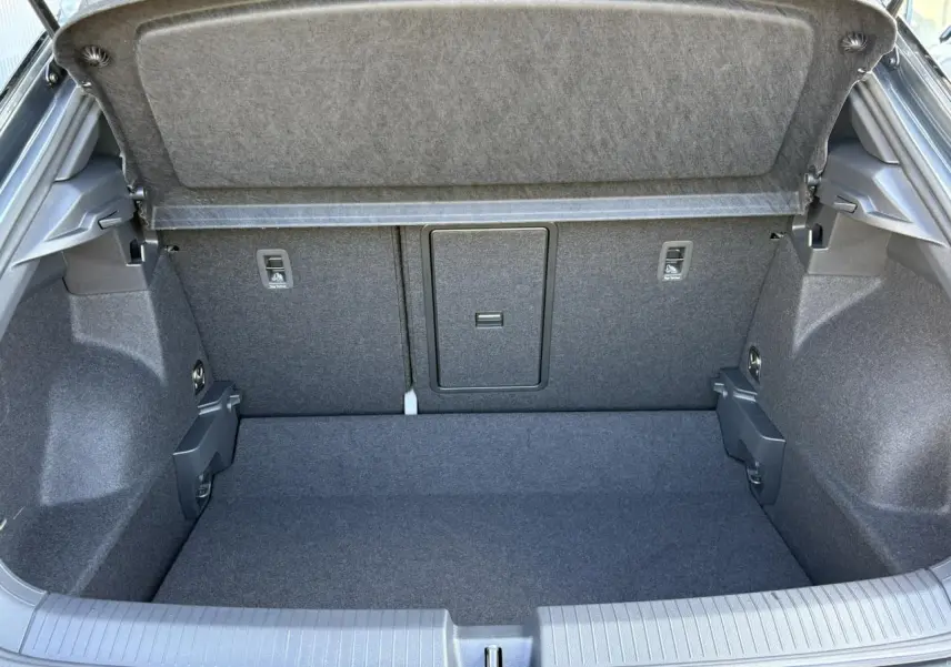 Vue intérieure du coffre spacieux et propre du Volkswagen T-Roc 2025, revêtement gris foncé uniforme.