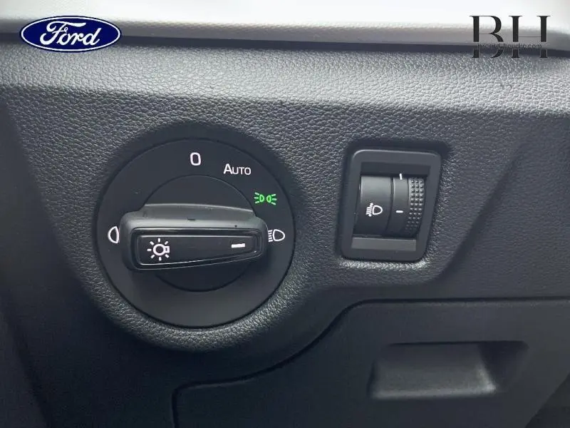 Gros plan sur le sélecteur de phares et réglage d’intensité lumineuse dans un Skoda Kamiq rouge Velvet 2022.