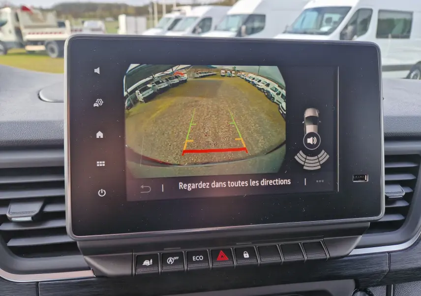 Vue de l'écran de caméra de recul du Nissan Primastar gris urbain, affichant le parking derrière le véhicule.