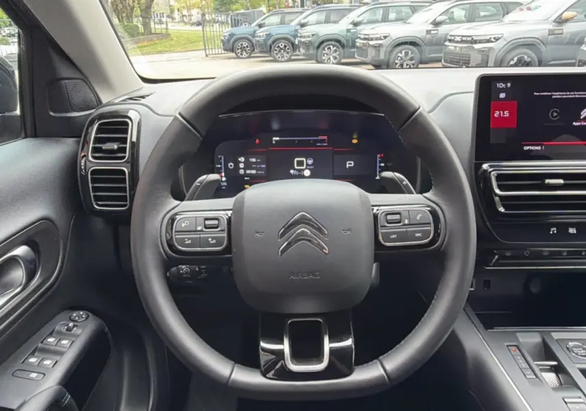 Vue intérieure centrée sur le volant cuir multifonctions d'un Citroën C5 Aircross gris platinium avec tableau de bord digital et écran tactile.