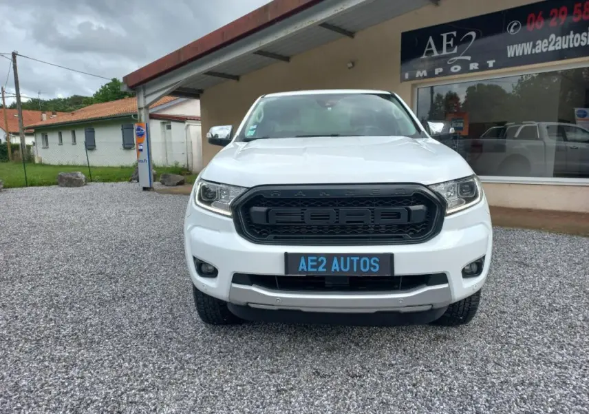 Vue de face d'un Ford Ranger blanc 2022 avec calandre noire marquée Ford et plaque AE2 AUTOS visible.
