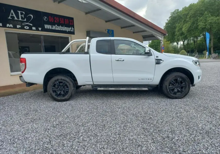 Ford Ranger Super Cabine Limited blanc vu de profil côté gauche, avec barres de protection et jantes noires.