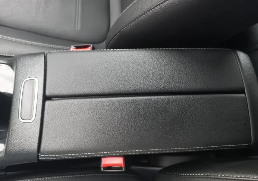 Vue rapprochée de l'accoudoir central en cuir noir avec surpiqûres blanches dans une Mercedes Classe A Berline A 200 AMG Line.