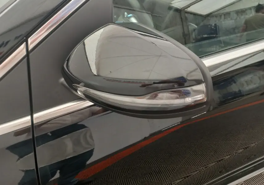 Gros plan sur le rétroviseur droit noir brillant avec clignotant intégré d'une Mercedes Classe A Berline A 200 AMG Line 2021.