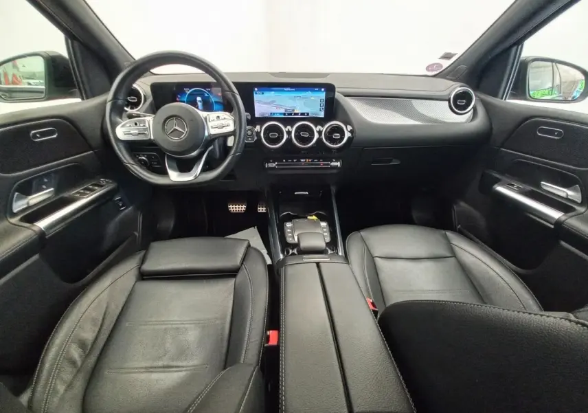 Vue intérieure avant de la Mercedes Classe A A 200 AMG Line 2021, avec sièges cuir noirs et tableau de bord numérique.