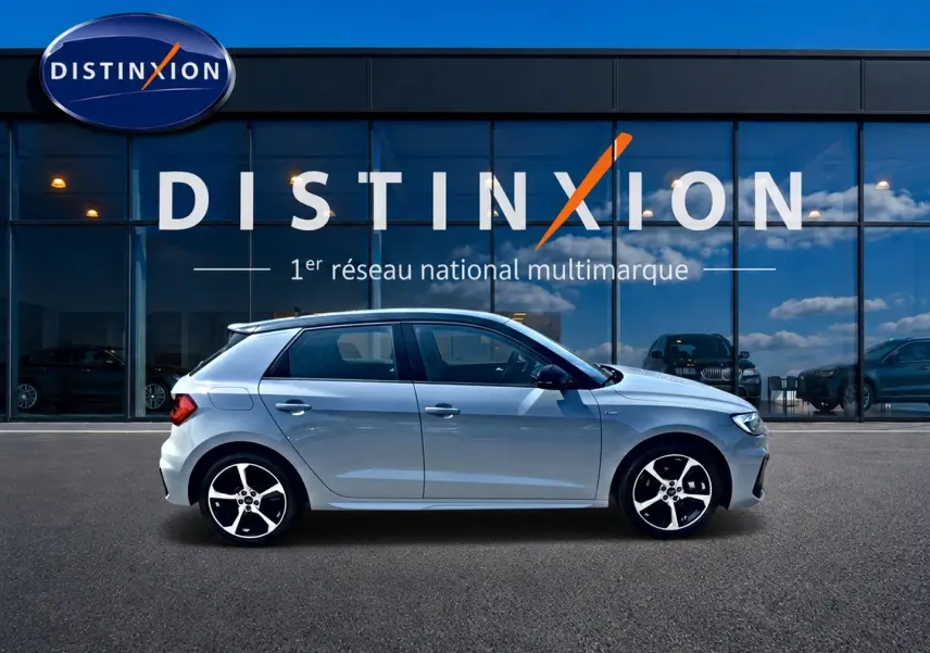 Audi A1 Sportback gris arrow vue de profil côté gauche devant une vitrine avec logo Distinxion.