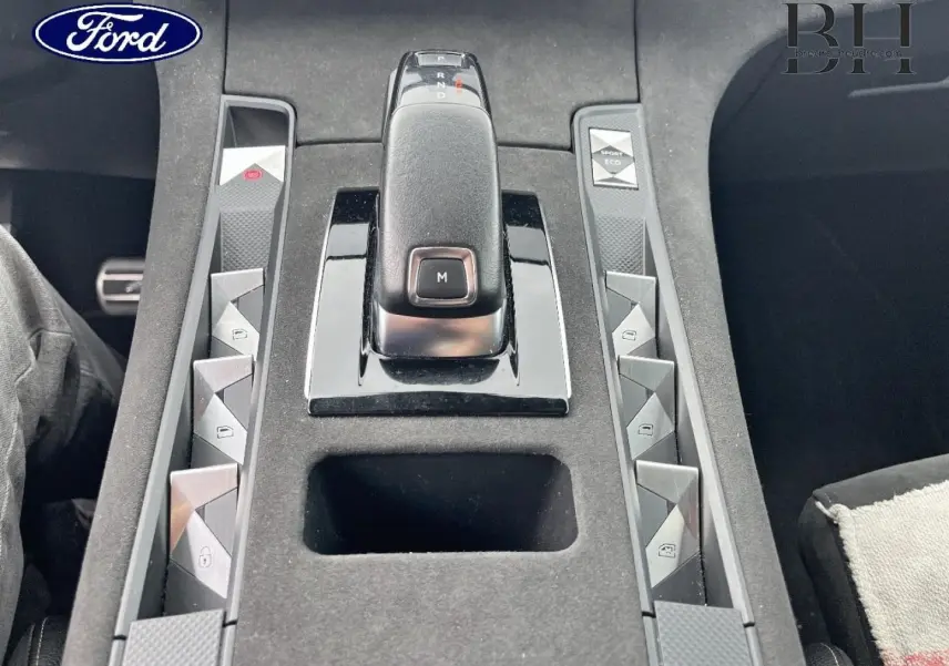 Console centrale vue de dessus avec levier de vitesses et boutons de commande dans un DS7 Crossback rouge Absolu.