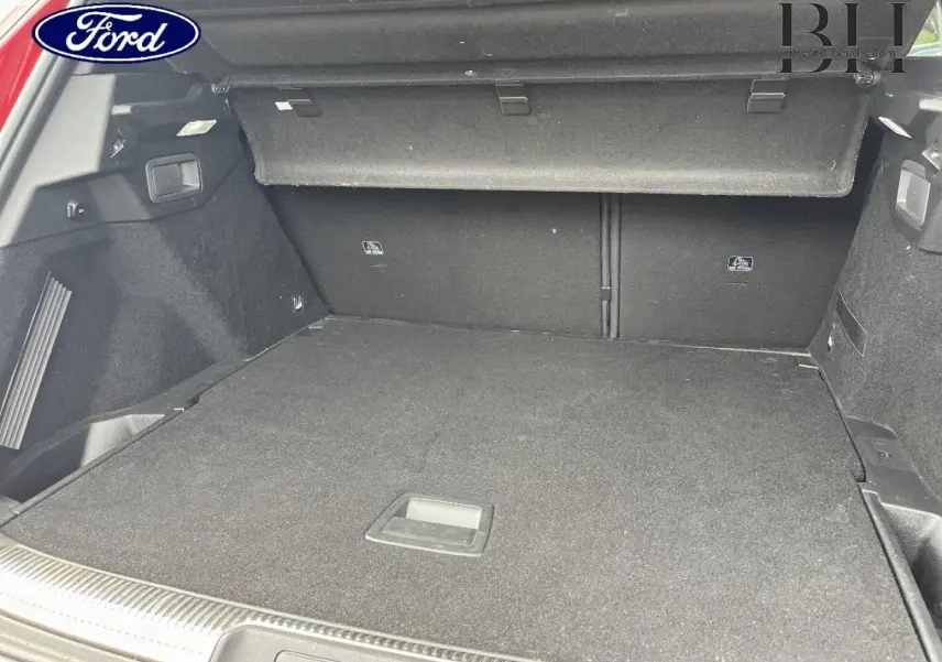 Coffre ouvert d'un DS7 Crossback rouge, vue intérieure montrant un espace de chargement spacieux et tapis noir.