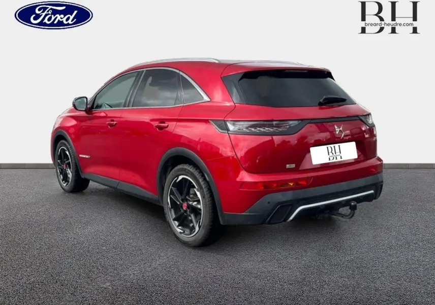 Vue 3/4 arrière droite du SUV DS7 Crossback rouge Absolu avec toit ouvrant panoramique et jantes noires.