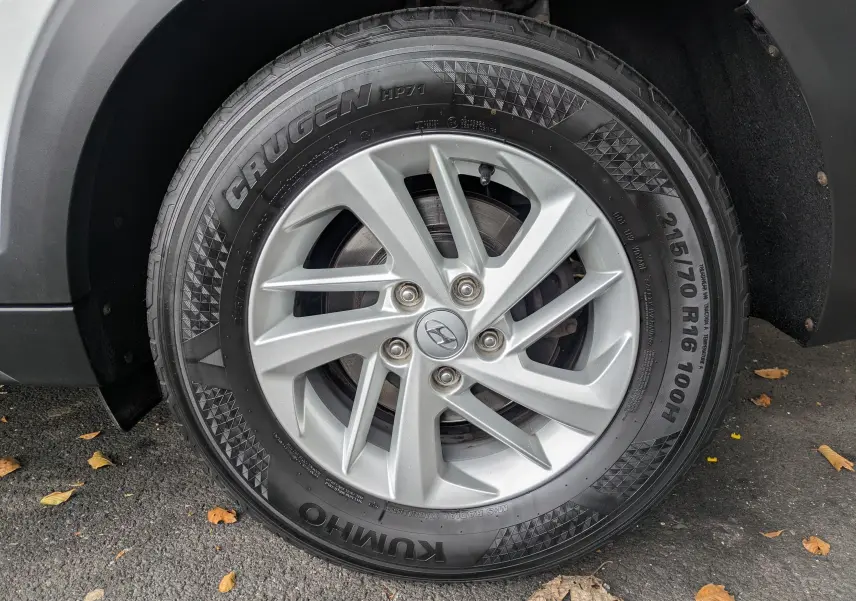 Gros plan sur la roue avant gauche du Hyundai Tucson blanc, mettant en valeur la jante argentée et le pneu Kumho.