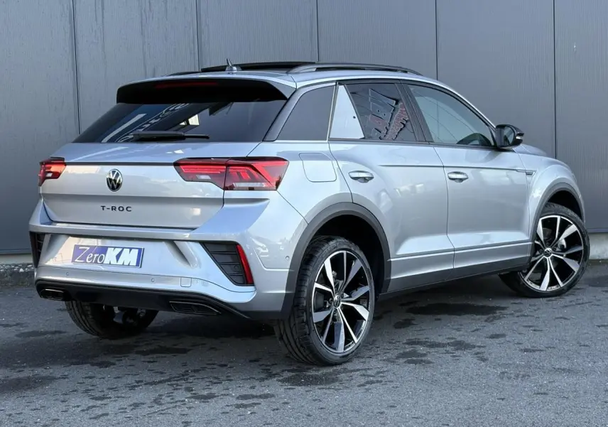 Volkswagen T-Roc gris pyrite vu en 3/4 arrière droit avec jantes alliage 19 pouces et toit ouvrant noir.