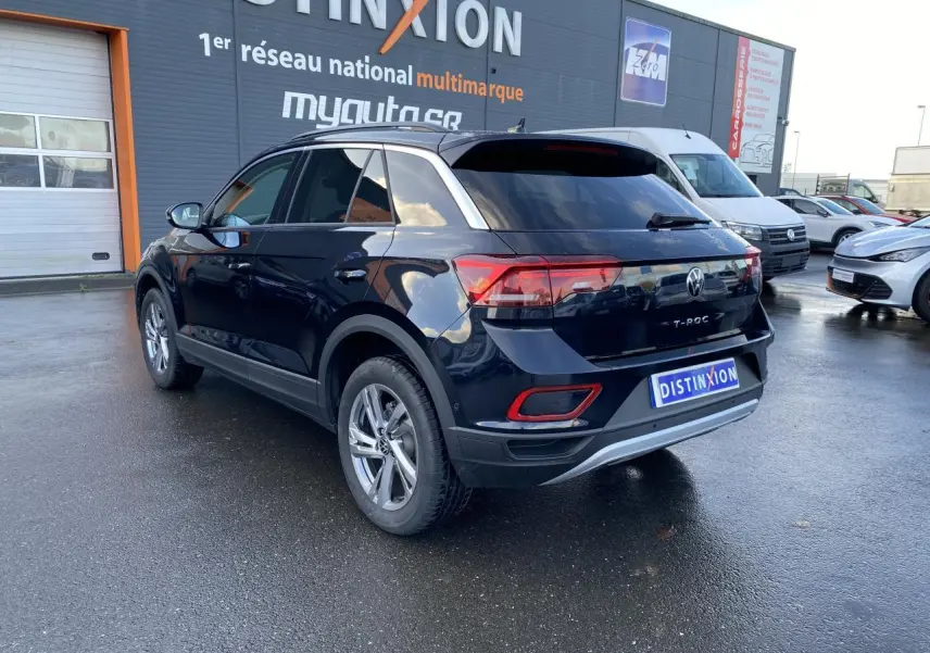 Volkswagen T-Roc noir nacré vu de trois quarts arrière droit, avec vitres surteintées et jantes alliage.