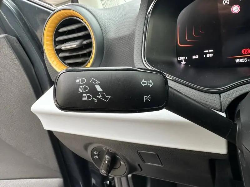 Gros plan sur la commande des clignotants du SEAT Arona 2025, avec tableau de bord et aérateur jaune visible.