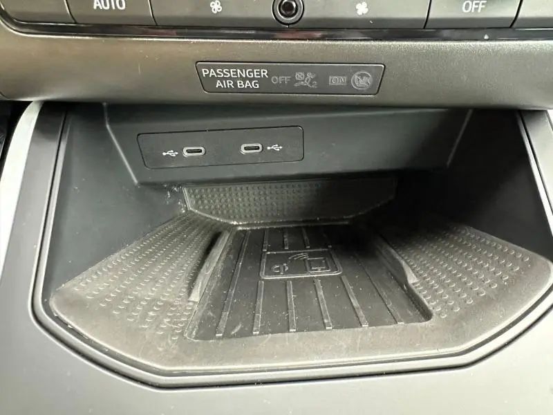 Gros plan sur la console centrale du SEAT Arona 2025, montrant les ports USB-C et le chargeur sans fil noir.