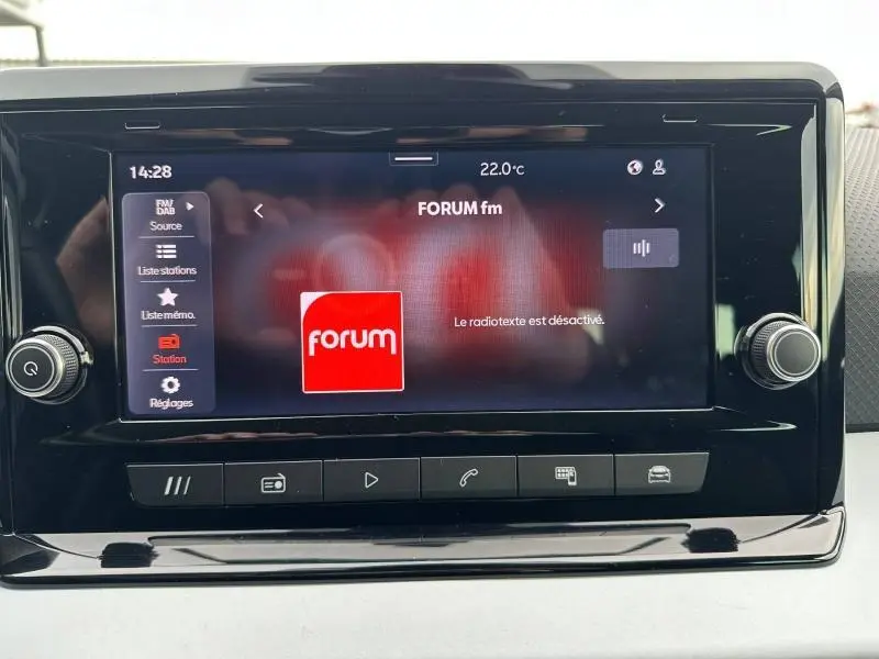 Écran tactile central du tableau de bord du SEAT Arona 2025 affichant la radio FM avec interface noire brillante.