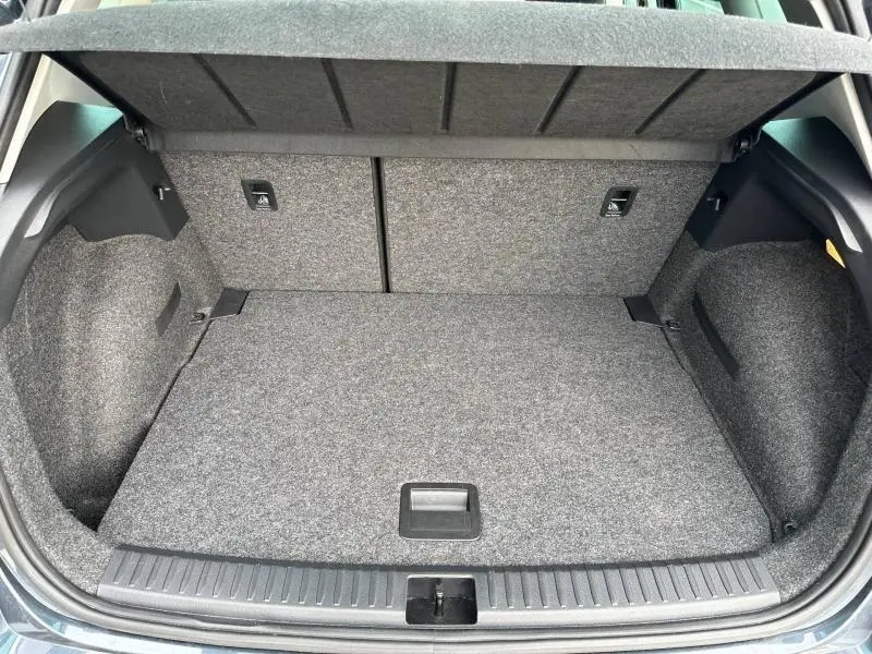 Coffre ouvert vu de l'arrière d'un SEAT Arona 2025, intérieur gris foncé avec revêtement tissu.