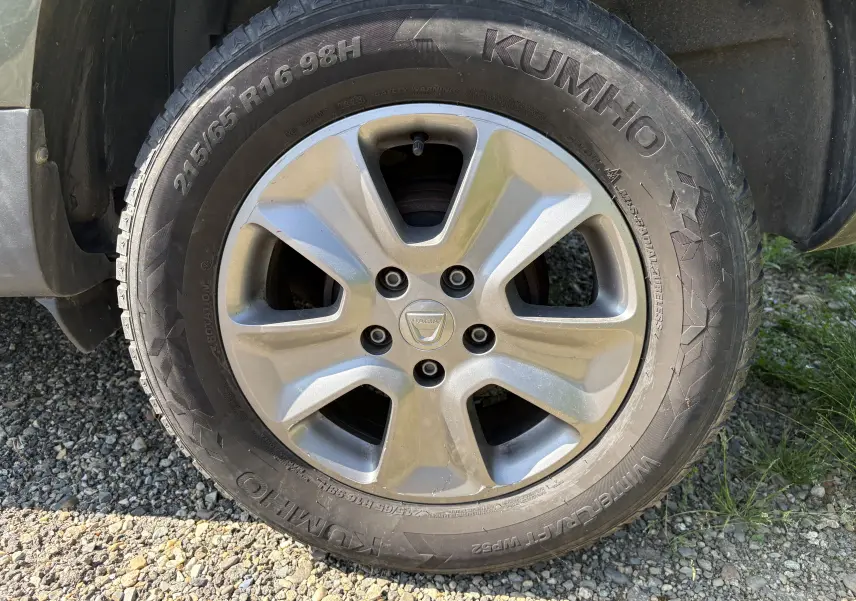 Gros plan sur la roue avant droite d'un Dacia Duster 1.5 DCI 110 2014 avec jante argentée et pneu Kumho.