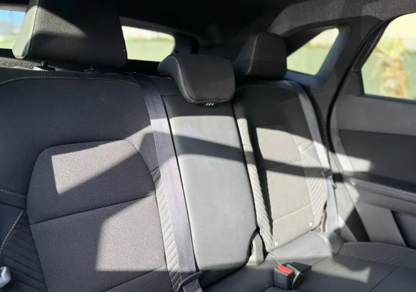 Vue intérieure de la banquette arrière en tissu gris foncé du Renault SYMBIOZ 2025 avec appuie-têtes et ceintures visibles.