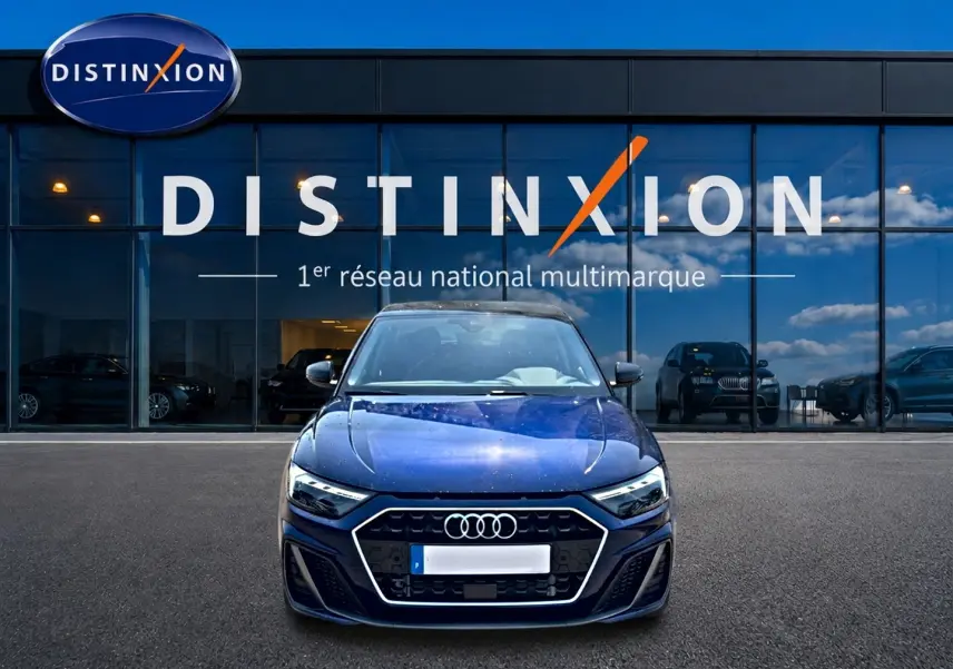 Audi A1 Sportback 30 TFSI 116 S line bleu foncé vue de face devant une vitrine Distinxion.