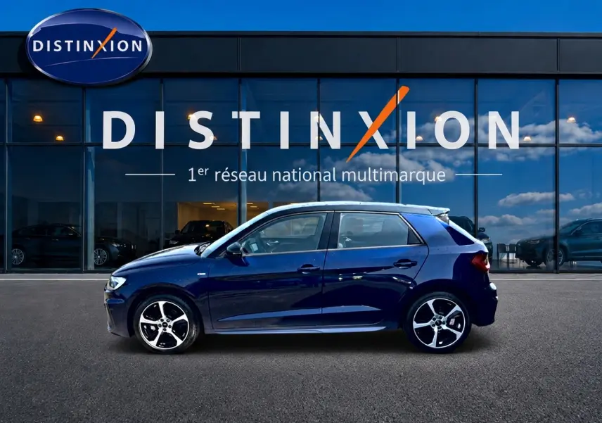 Audi A1 Sportback bleu foncé vue de profil côté gauche devant une vitrine avec logo Distinxion.