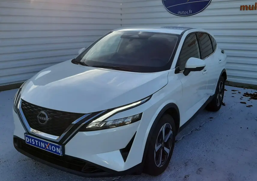 Nissan Qashqai blanc lunaire vu en 3/4 avant droit, avec calandre noire et phares fins LED distinctifs.