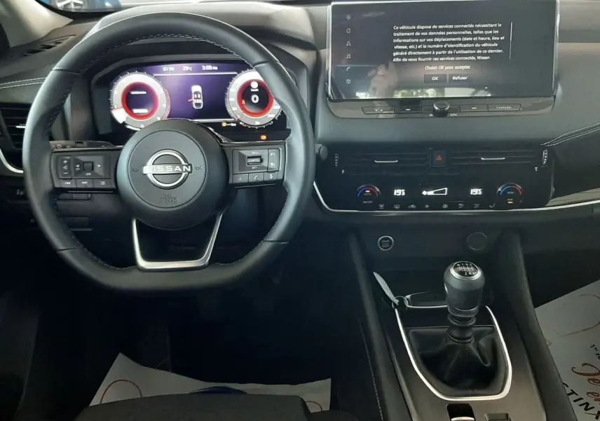 Vue intérieure du tableau de bord du Nissan Qashqai blanc lunaire 2022, avec volant multifonction et écran tactile central.
