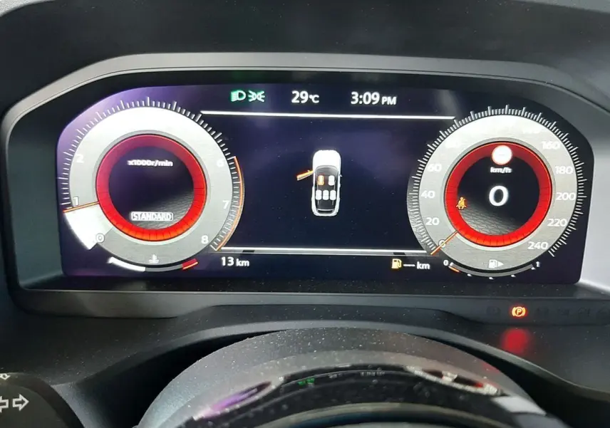 Tableau de bord numérique du Nissan Qashqai blanc lunaire 2022, affichant vitesse, régime et état des portes ouvertes.