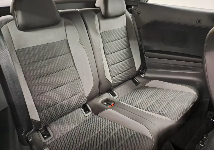 Vue rapprochée des sièges arrière en tissu gris et alcantara du Volkswagen T-Roc Cabriolet 2022 avec capote noire.