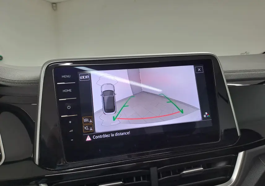 Écran tactile intérieur du Volkswagen T-Roc Cabriolet montrant la caméra de recul avec lignes de guidage vertes et rouges.