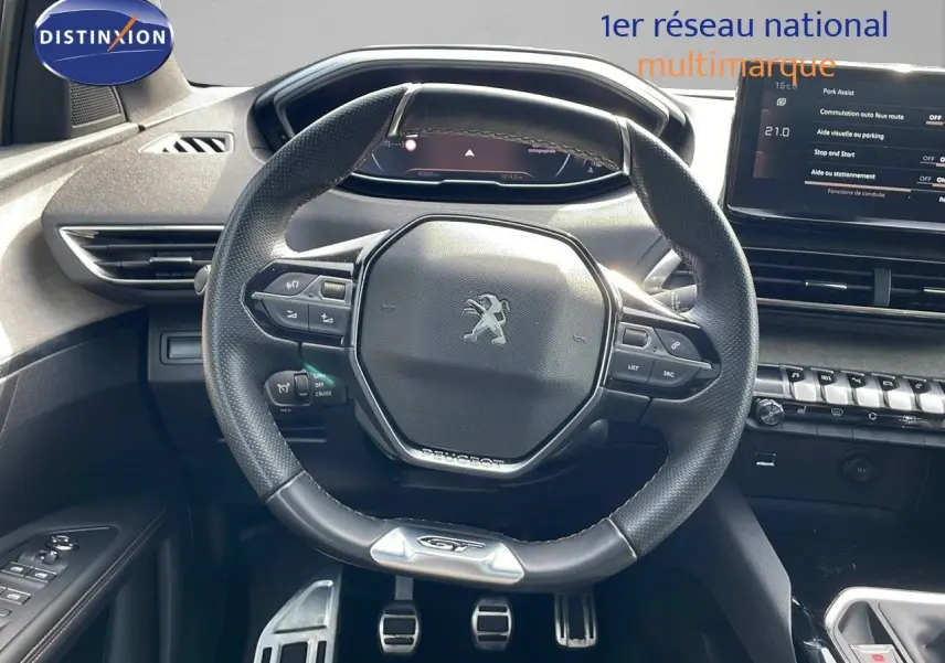 Vue intérieure centrée sur le volant GT de la Peugeot 3008 2023, avec tableau de bord et console moderne visibles.
