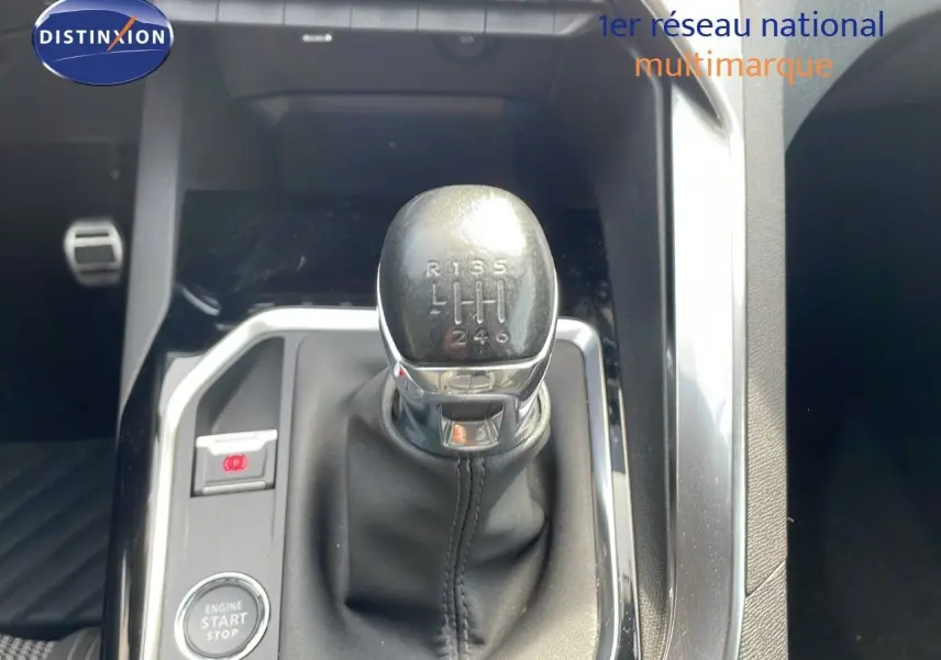 Le levier de vitesses manuel en cuir noir du Peugeot 3008 gris platinium, vue rapprochée de la console centrale.