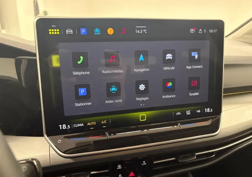 Écran tactile central affichant les options multimédia et climatisation dans l’habitacle d’une Volkswagen Golf 2025.