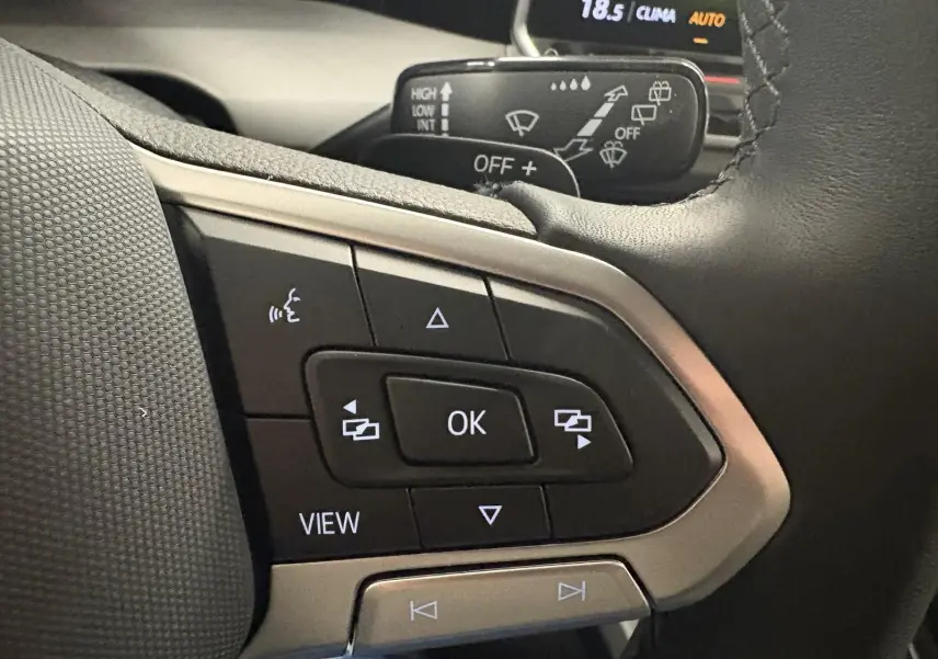 Gros plan sur les commandes au volant côté gauche de la Volkswagen Golf 1.5 eTSI 2025 en Bleu Anémone.