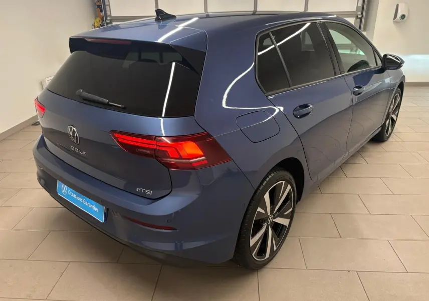 Vue 3/4 arrière droite d'une Volkswagen Golf 1.5 eTSI 116 DSG7 Bleu Anémone avec jantes alliage 18'' Catania.