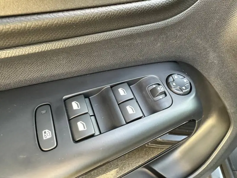 Gros plan sur les commandes de lève-vitres et réglage des rétroviseurs côté conducteur du Citroën C5 Aircross gris Platinium.