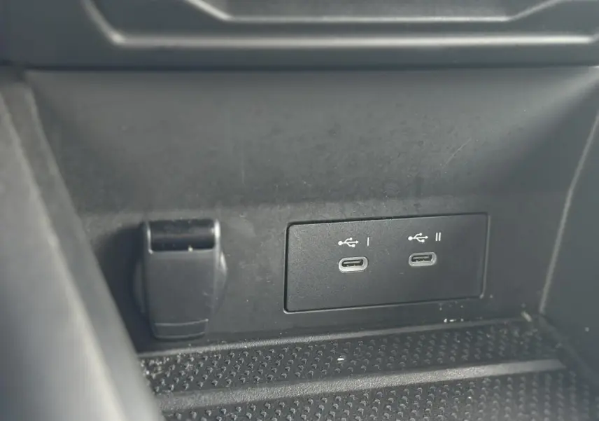 Détail des ports USB-C doubles et prise 12V dans le rangement central du Renault Symbioz E-Tech Full Hybrid bleu.
