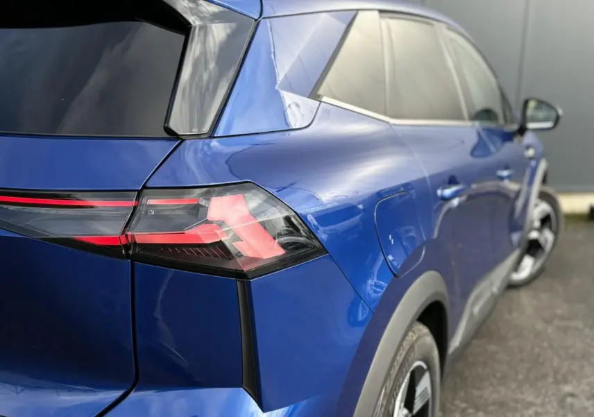 Vue 3/4 arrière droite d’une Renault SYMBIOZ bleu Iron avec feux arrière LED et jantes 18 pouces Gravity.