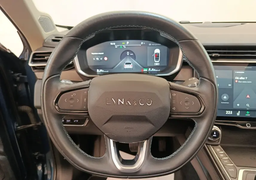 Vue rapprochée du volant noir du Lynk & Co 01 avec tableau de bord numérique et écran tactile central visible.
