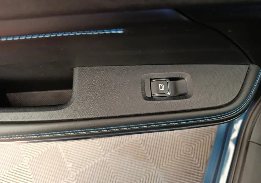 Gros plan sur la commande de lève-vitre sur la porte côté gauche avec surpiqûres bleues du LINK & CO 01 bleu.