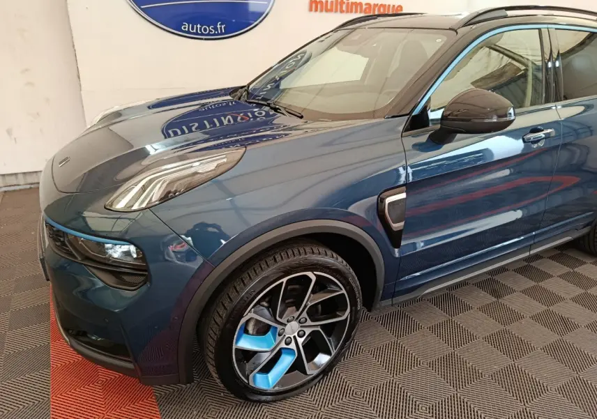 Vue 3/4 avant gauche du SUV hybride rechargeable LINK & CO 01 bleu avec jantes bicolores et détails noirs.