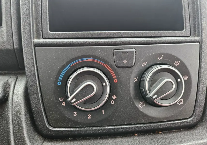Tableau de bord du Fiat Ducato Combi 2014 montrant les commandes de climatisation avec réglages manuels.