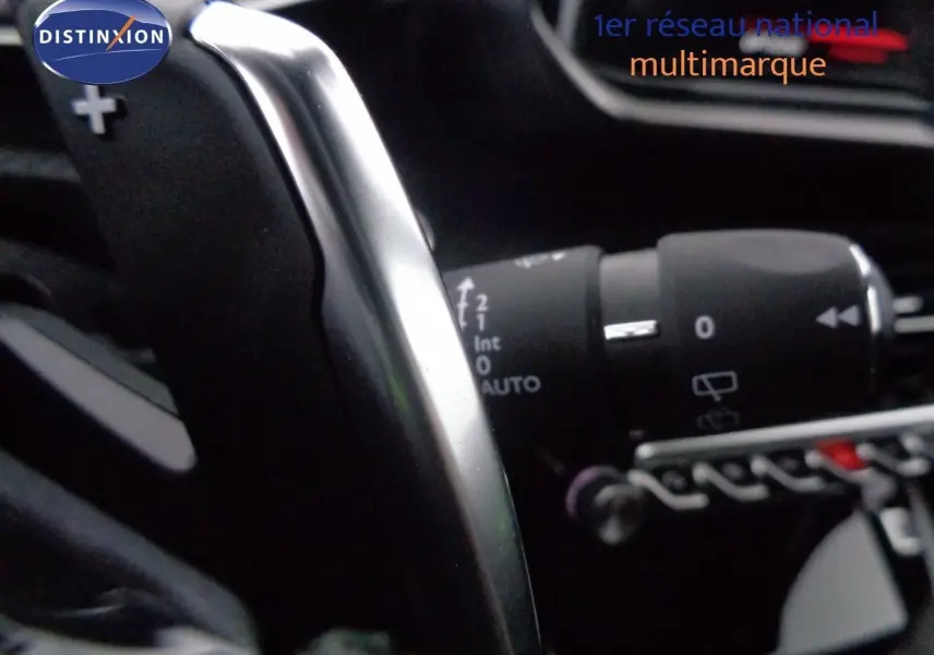 Gros plan sur la palette de changement de vitesses argentée dans l'habitacle noir du Peugeot 2008 GT 2023.