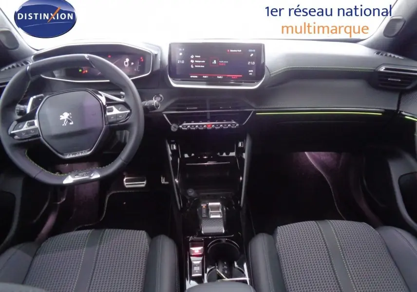 Intérieur du Peugeot 2008 GT 2023 vu de face, tableau de bord moderne avec écran tactile et sellerie noire à surpiqûres vertes.
