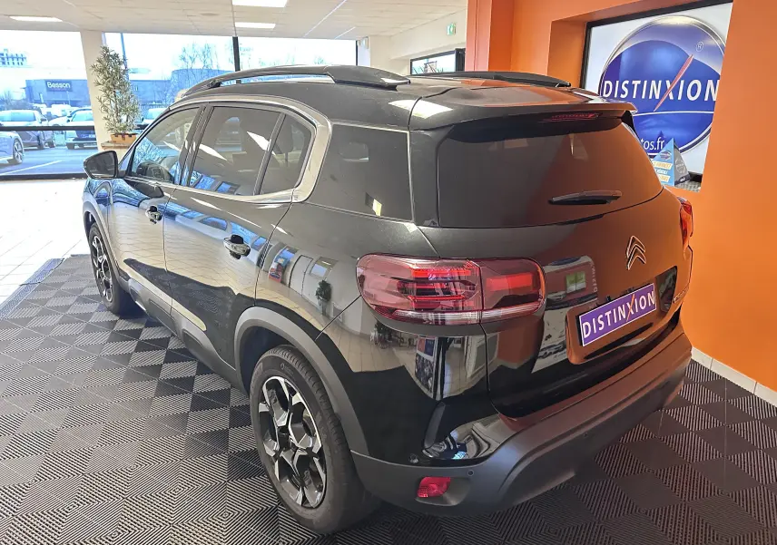Vue 3/4 arrière droite du Citroën C5 Aircross hybride noir 2025 avec jantes alliage biton et vitres arrière surteintées.