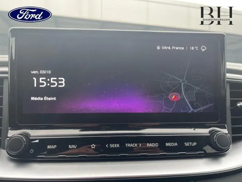 Écran tactile central de la Kia CEE'D 2023 affichant l’heure et la carte, vue de face en intérieur.