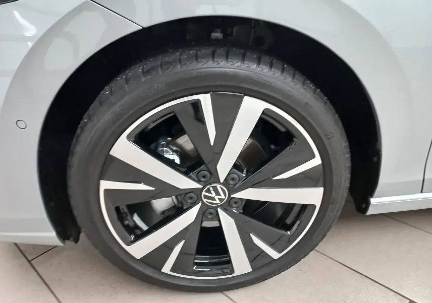 Gros plan sur la jante alliage 18'' Catania noire et argentée de la Volkswagen Golf 2025 Argent Dolomite, côté gauche.