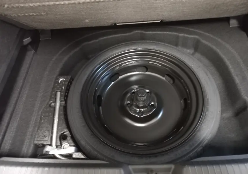 Vue rapprochée de la roue de secours noire dans le coffre d'une Volkswagen Golf 1.5 eTSI 116 BVM6 Argent Dolomite.