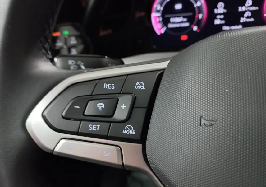 Gros plan sur les commandes de régulateur de vitesse au volant d’une Volkswagen Golf 1.5 eTSI 2025.